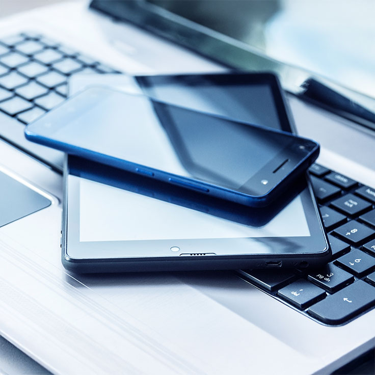 Ein moderner schwarzer Bürotelefon mit einem Tastenfeld, auf einem Tisch neben einem Computerbildschirm.