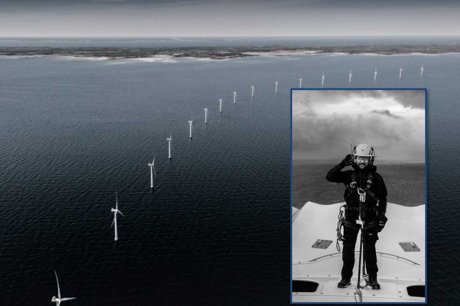 Ein Techniker steht auf einem Windrad und salutiert, während weitere Windparks im Hintergrund im Meer sichtbar sind.