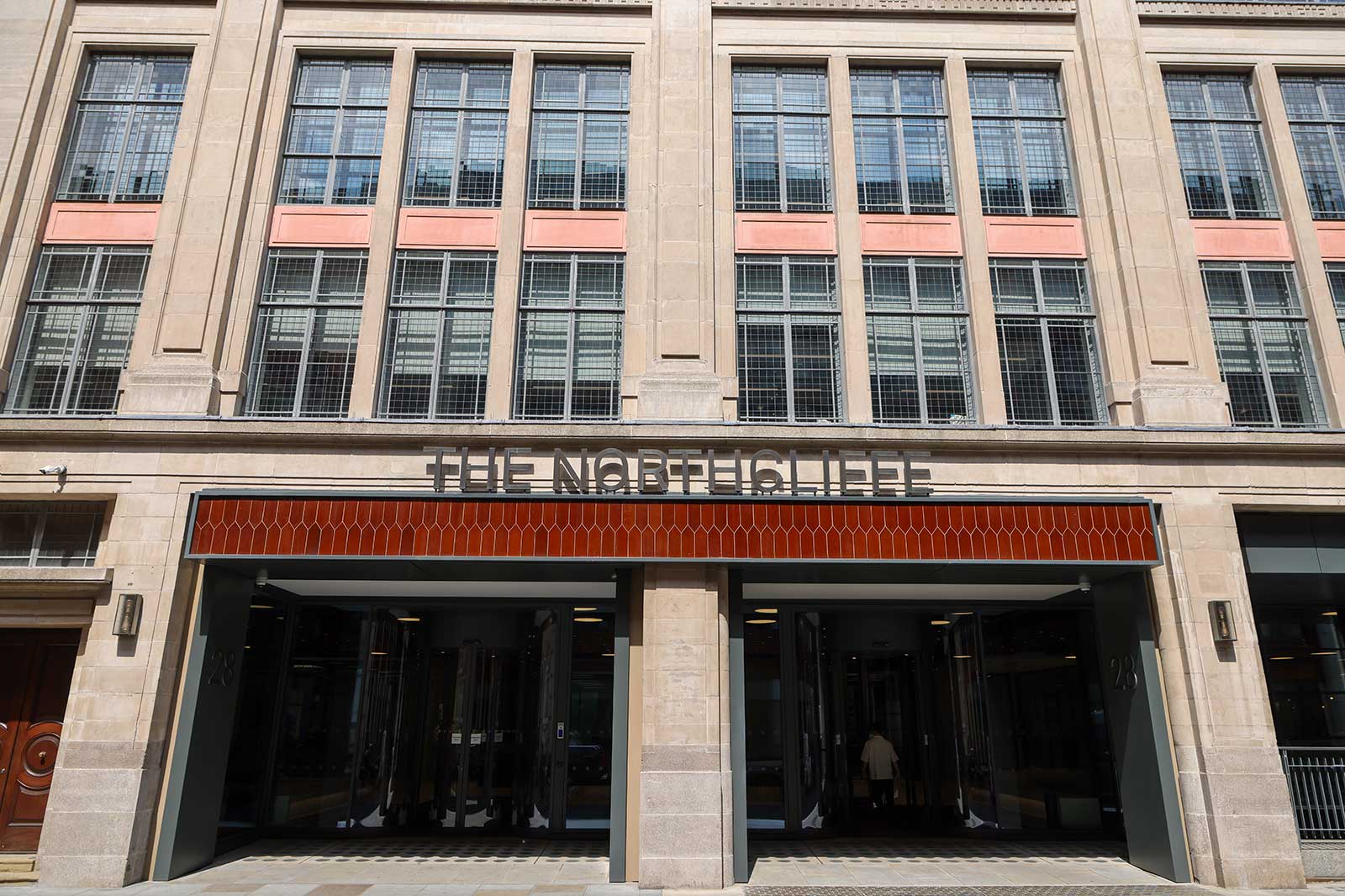 Beige stone facade with tall rectangular windows above a recessed glass entrance topped by a red tiled canopy bearing the sign "THE NORTHCLIFFE".