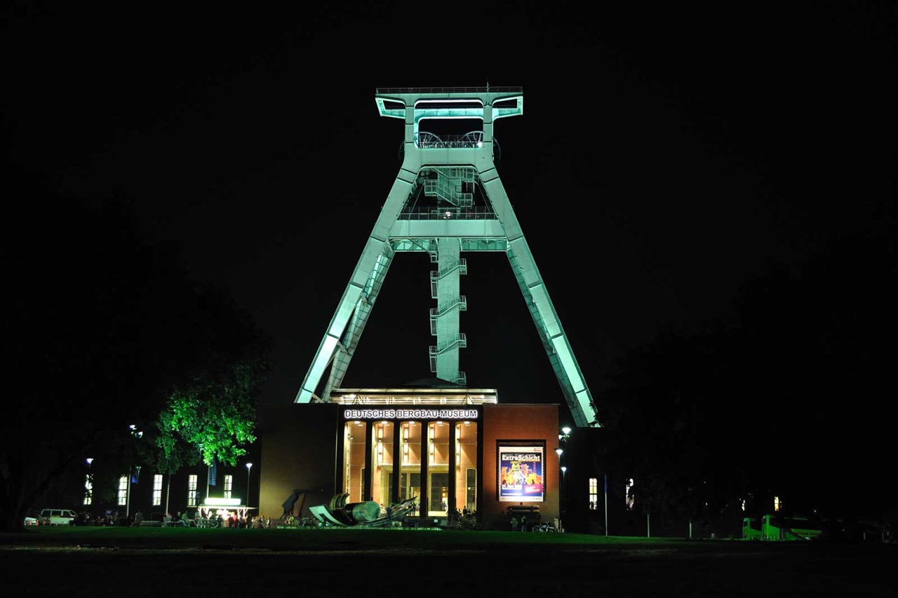 The German Mining Museum at night, illuminated with green light, showcases the striking headframe.