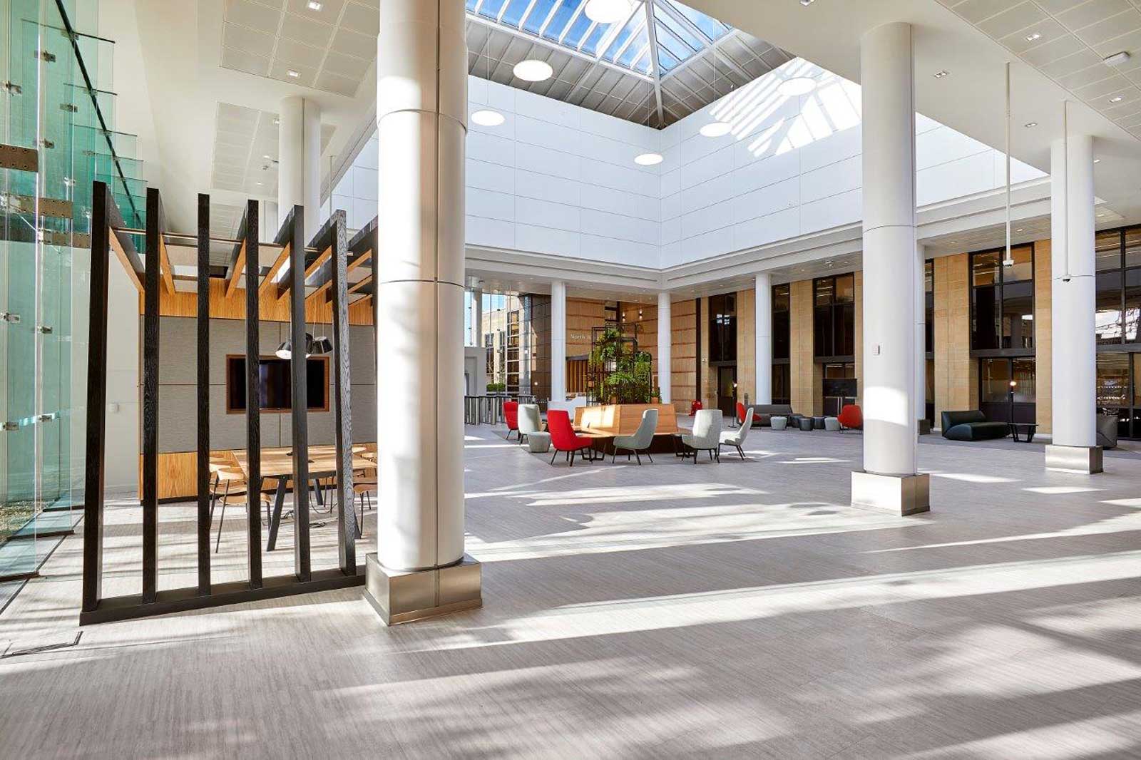 A modern interior with large windows, stylish furniture, and a central meeting table.